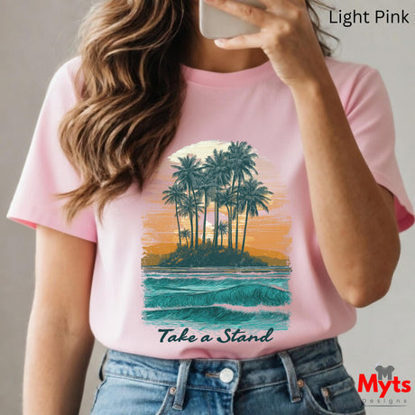 Person wearing a pink t-shirt with a tropical island design and 'Take a Stand' text, taking a selfie.