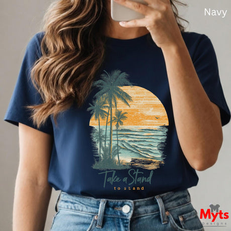 Person wearing a navy t-shirt with a palm tree and sunset design, holding a phone.