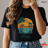 Person wearing a black t-shirt with a palm tree design and 'Take a Stand' text, holding a phone.