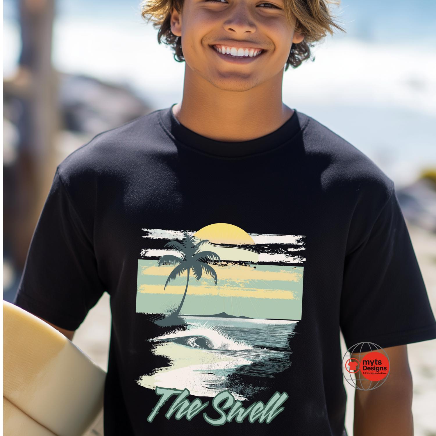 Person wearing a black t-shirt with a beach graphic and 'The Swell' text, holding a surfboard on a beach.