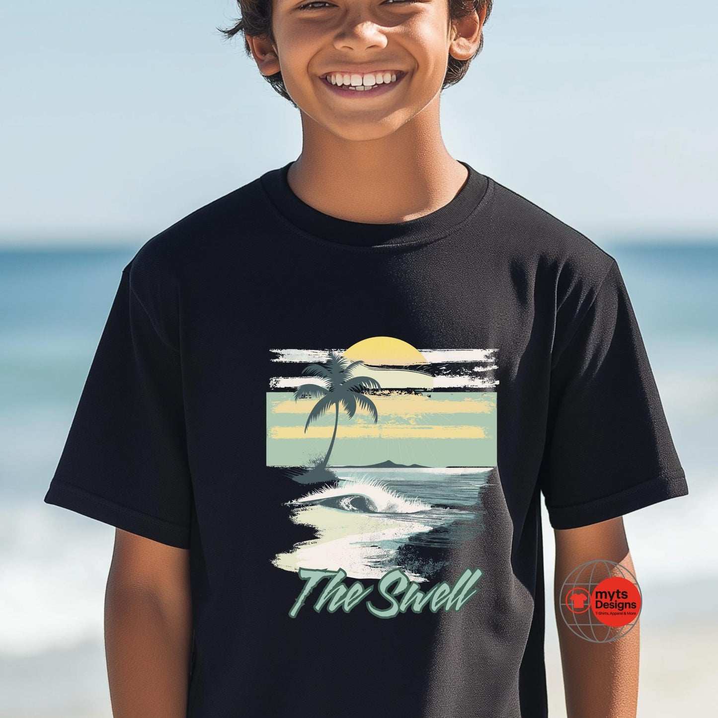Child wearing a black t-shirt with a beach graphic and 'The Swell' text, standing on a beach.