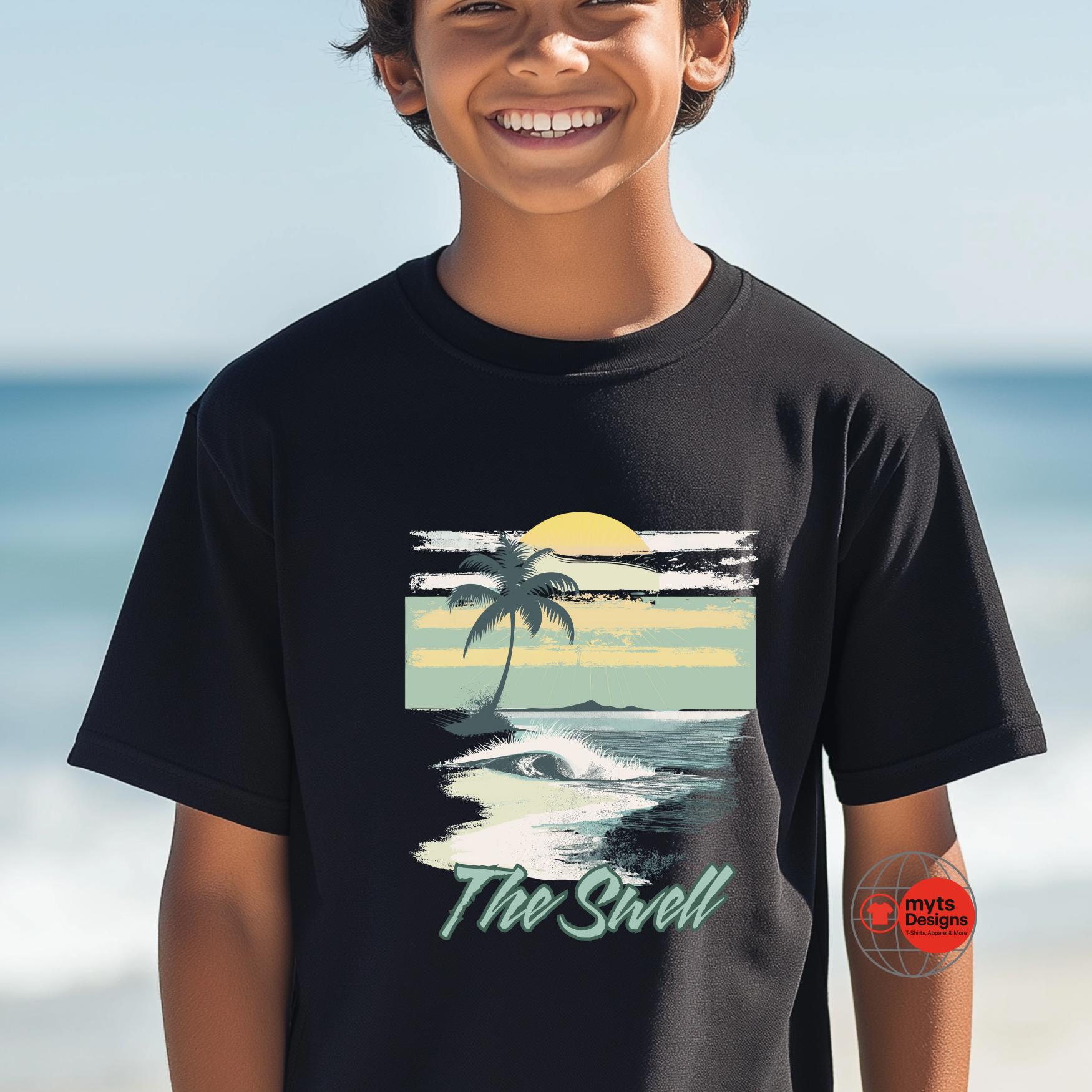Child wearing a black t-shirt with a beach graphic and 'The Swell' text, standing on a beach.