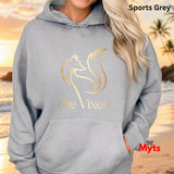 Person wearing a sports grey hoodie with 'The Vixen' logo, standing on a beach.