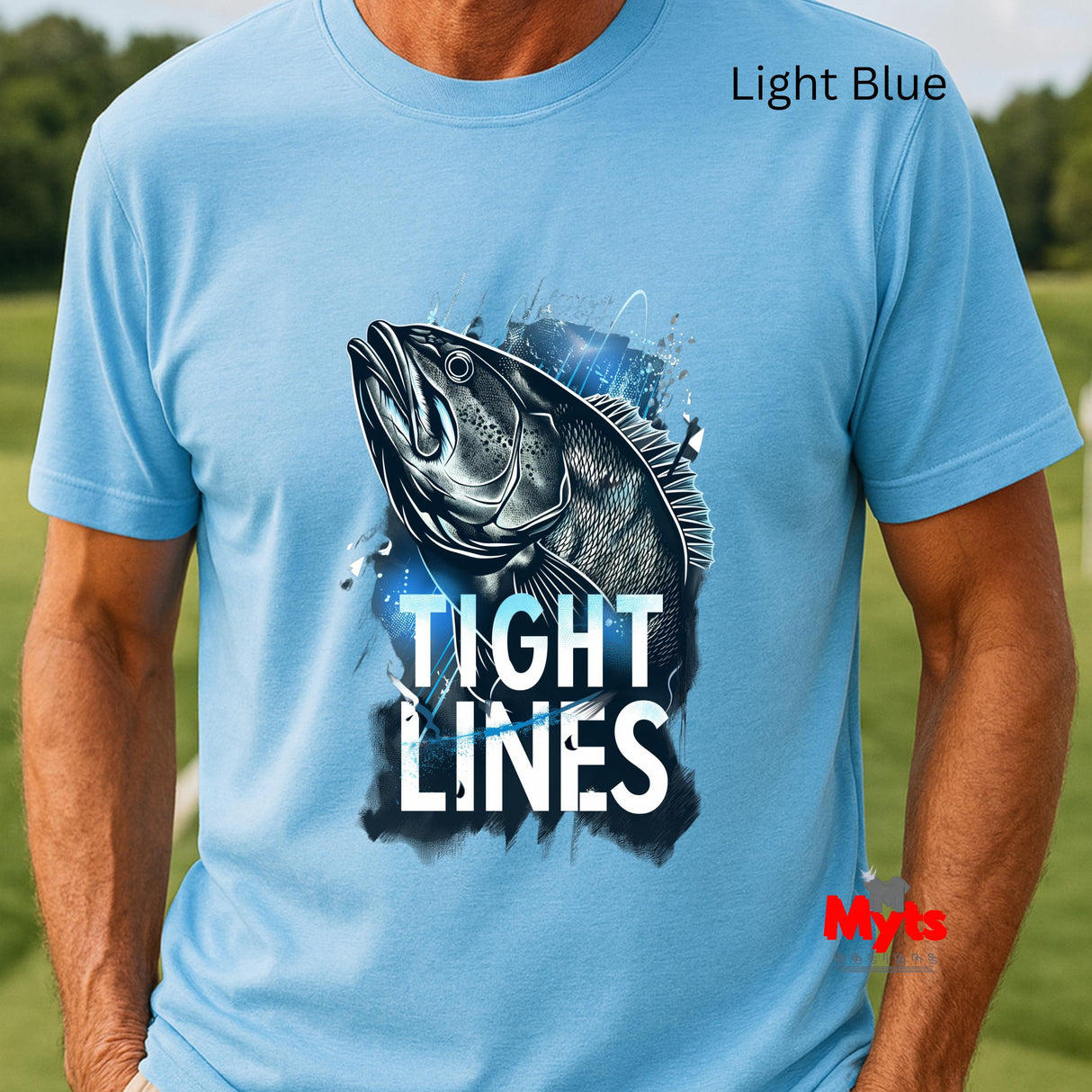 Light blue t-shirt with a fish graphic and 'Tight Lines' text on a grassy background
