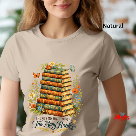 Person wearing a Natural color t-shirt with a graphic of stacked books and flowers, text 'There's no such thing as too many books', and 'Myts' branding.
