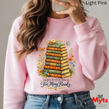 Person wearing a pink sweatshirt with a book-themed design and 'Myts Designs' branding.