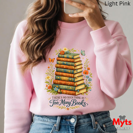 Person wearing a pink sweatshirt with a book-themed design and 'Myts Designs' branding.