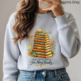 Person wearing a gray sweatshirt with a book-themed design and text.