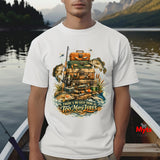 Person wearing a white t-shirt with a fishing-themed graphic and text, standing by a lake.