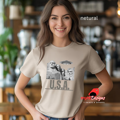 Netural colored Mt. Rushmore T-shirt, worn by a young woman in a blurred kitchen setting
