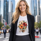 Woman wearing a white Unbound Beauty graphic T-shirt with red, orange and cream poppy flowers, geometric accents and retro typography.