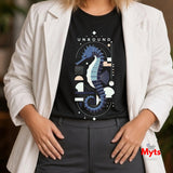 Close-up with white shirt: “Black UNBOUND seahorse graphic T-shirt worn under an open white shirt”