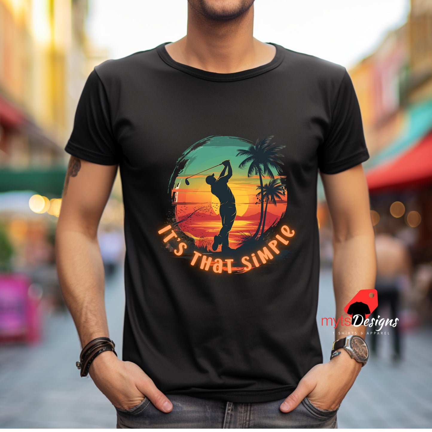 Person wearing a black t-shirt with a colorful graphic and text, standing in an urban setting.