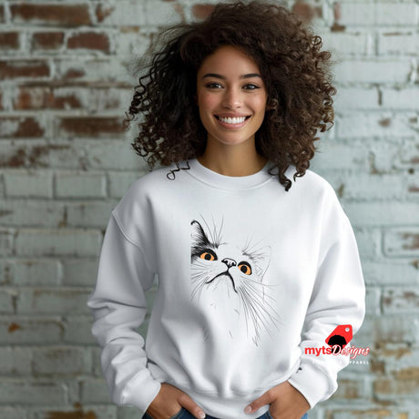 A woman  standing in front of a brick wall wearing a white sweatshirt with a minimalist cat design