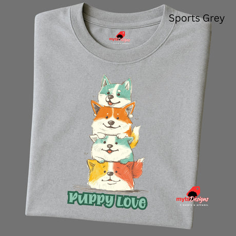 A folded sports grey T-shirt featuring a colorful graphic of four stacked cartoon puppies in teal, orange, cream, and yellow shades with the words “Puppy Love” in playful green text below

