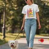 Woman walking a dog in a park wearing a graphic t-shirt