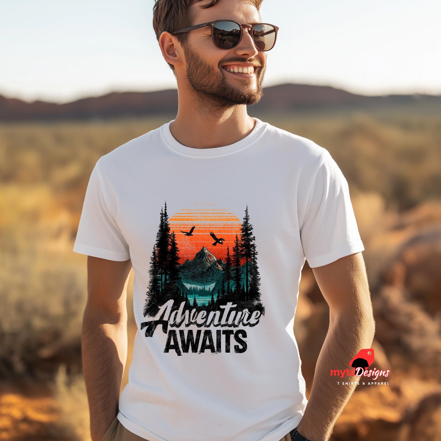 Man wearing a white t-shirt with 'Adventure Awaits' design in a desert setting