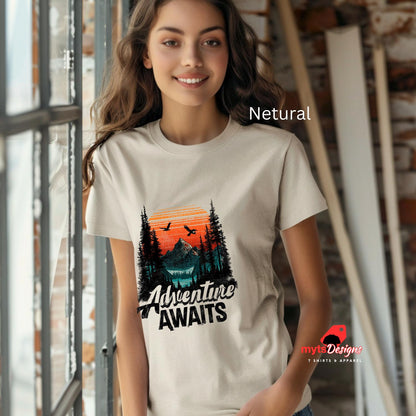 Woman wearing a t-shirt with a nature graphic and 'Adventure Awaits' text, standing indoors.