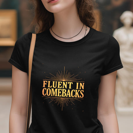 Person wearing a black t-shirt with 'Fluent in Comebacks' text in gold.
