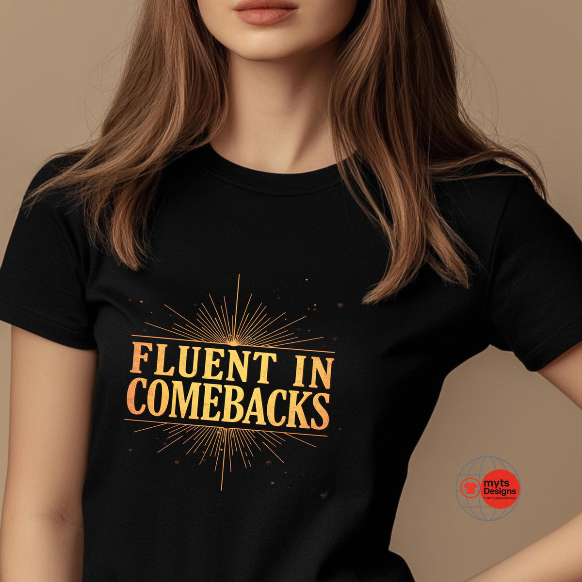 Person wearing a black t-shirt with 'Fluent in Comebacks' in gold text on a beige background