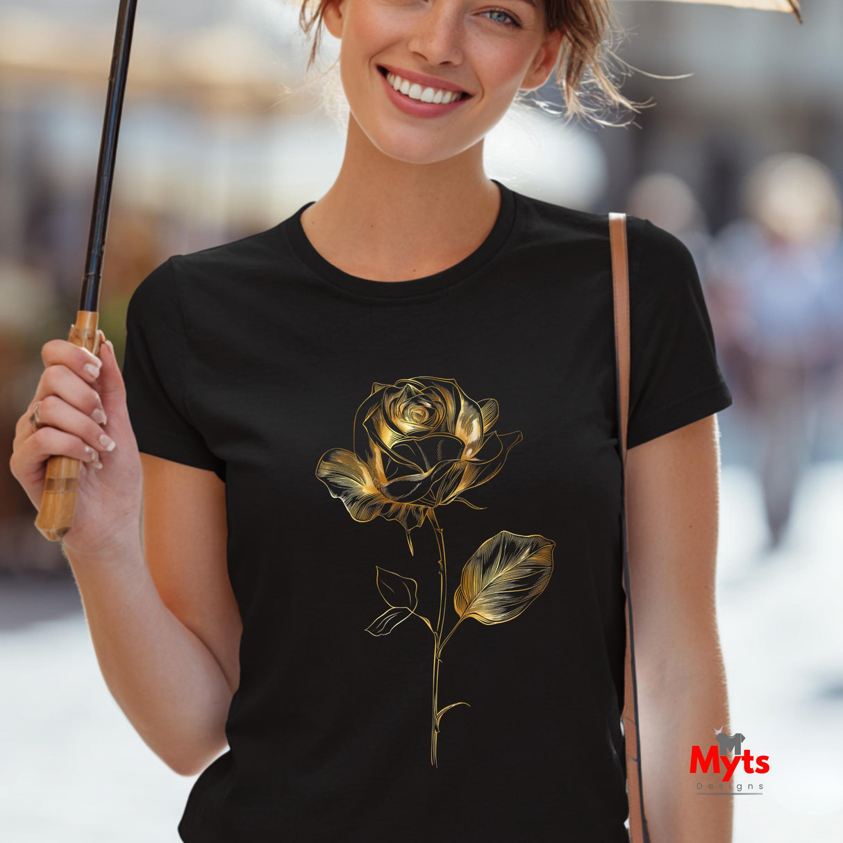 Woman wearing a black t-shirt with a gold rose design, holding an umbrella.