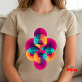 Person wearing a Natural (Beige) t-shirt with a colorful geometric design, sitting on a couch.