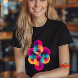 Woman wearing a black t-shirt with a colorful geometric design, sitting in a blurred indoor setting.