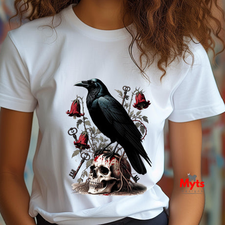 A person wearing a white short-sleeve T-shirt with a dark gothic-style graphic print featuring a large black raven perched on a skull, with red bell-shaped flowers and ornate keys.