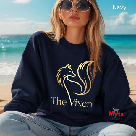 Woman wearing a navy sweatshirt with 'The Vixen' logo on a beach