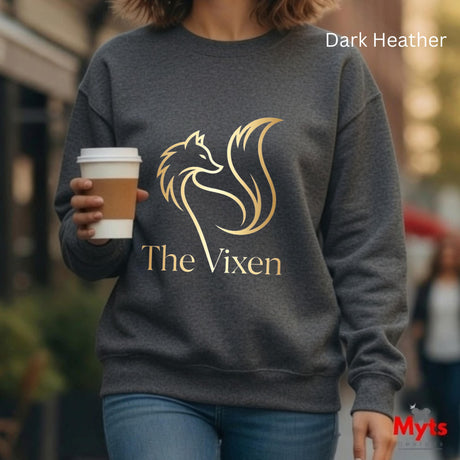 Person wearing a dark Heather sweatshirt with 'The Vixen' logo, holding a coffee cup.
