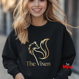 Woman wearing a black sweatshirt with 'The Vixen' logo, standing outdoors.