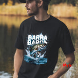 Man wearing a black t-shirt with a fish graphic and 'BARRA BARRA' text, standing outdoors by a body of water.