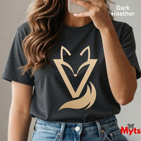 Woman wearing a Dark Heather Vixen minimalist fox graphic T-shirt featuring a modern gold-toned geometric fox symbol with a flowing tail design.