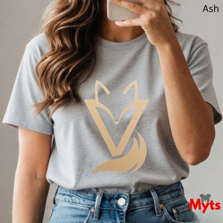 Woman wearing a Ash Vixen minimalist fox graphic T-shirt featuring a modern gold-toned geometric fox symbol with a flowing tail design.