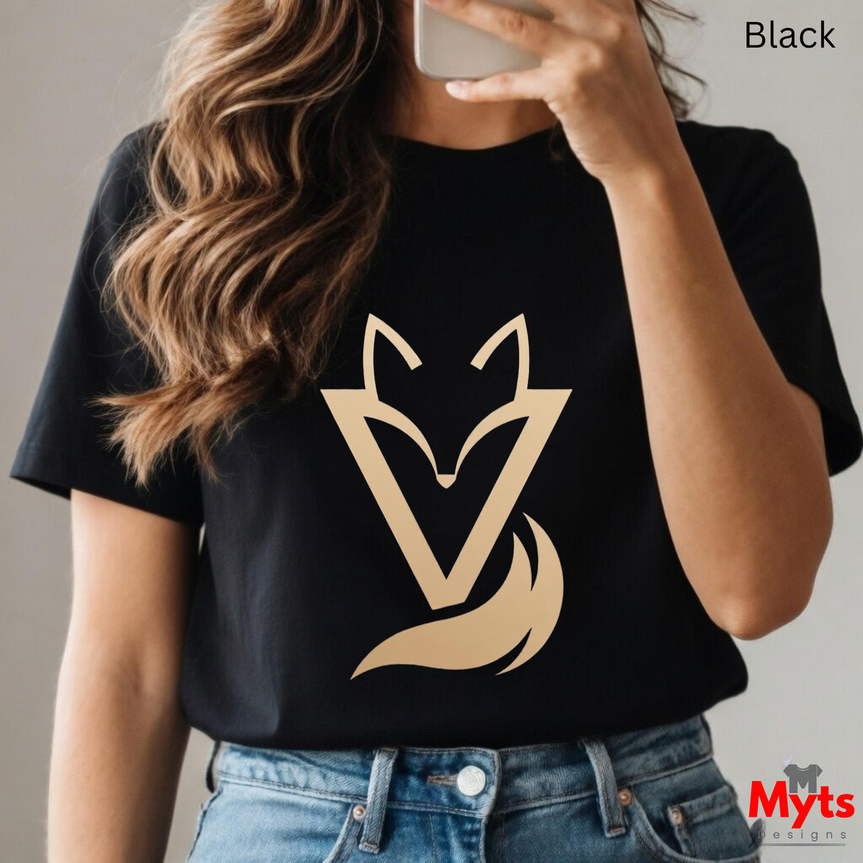 Woman wearing a black Vixen minimalist fox graphic T-shirt featuring a modern gold-toned geometric fox symbol with a flowing tail design.