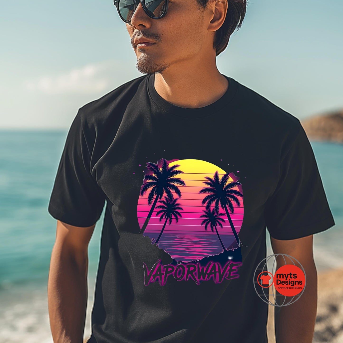 Man wearing a black t-shirt with a colorful palm tree design on a beach