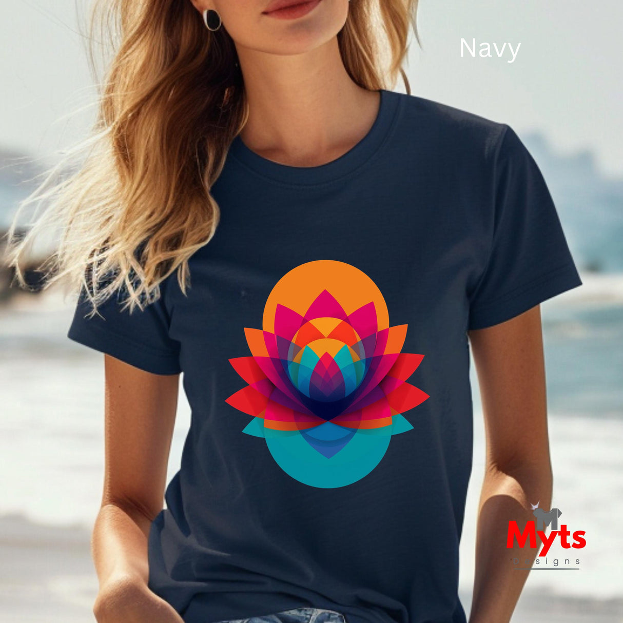 Person wearing a navy t-shirt with a colorful flower design, sitting by a body of water.