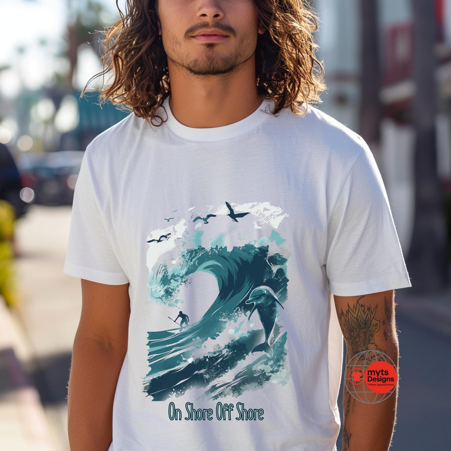 Person wearing a white t-shirt with a wave design and 'On Shore Off Shore' text, blurred background