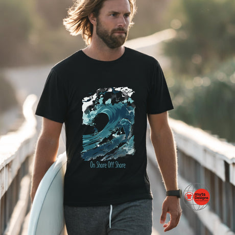 Man wearing a black t-shirt with a blue wave design, holding a surfboard on a wooden bridge.