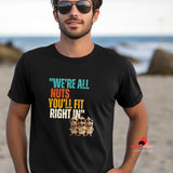 A man wearing sunglases and a black funny retro t-shirt at the beach