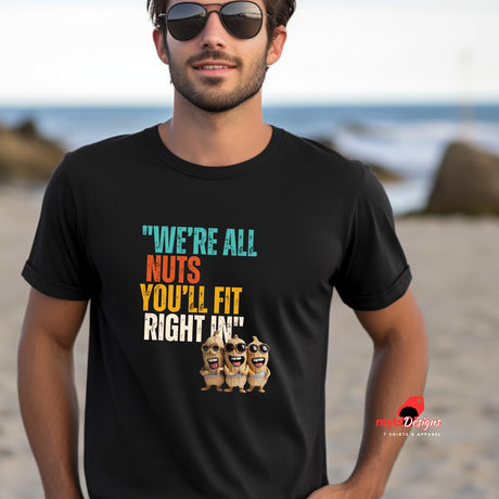 A man wearing sunglases and a black funny retro t-shirt at the beach