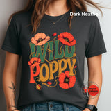 A woman wearing a dark heather charcoal t-shirt with a colorful graphic that reads 'WILD POPPY' in green and mustard yellow, decorated with red poppy flowers. The text 'Dark Heather' is visible in the top right corner, and a 'myt Designs' watermark is visible in the bottom right.