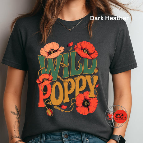 A woman wearing a dark heather charcoal t-shirt with a colorful graphic that reads 'WILD POPPY' in green and mustard yellow, decorated with red poppy flowers. The text 'Dark Heather' is visible in the top right corner, and a 'myt Designs' watermark is visible in the bottom right.