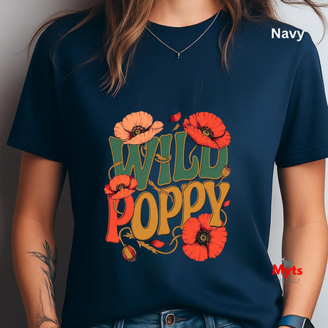 A person wearing a navy blue graphic T-shirt with the words “WILD POPPY” in large orange, yellow, and green lettering, surrounded by red-orange poppy flowers. The word “Navy” appears in white text in the upper right, and a small “Myts” watermark is visible near the lower right.
