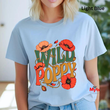 A woman wearing a light blue graphic t-shirt with a colorful 'WILD POPPY' design in orange, red, and green, with a 'Light Blue' text overlay in the top right.
