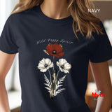 A woman wearing a navy blue t-shirt with a graphic of three poppies (one red, two white) and the text 'Wild Poppy Spirit'. The image has 'NAVY' text overlay in the top right and a 'Myts' logo in the bottom right.