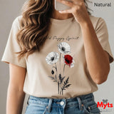 A woman wearing a Natural graphic T-shirt with a poppy design and the text 'Wild Poppy Spirit', paired with blue jeans. The image is a mirror selfie with a phone, and the words 'Natural' and 'Myts designs' are visible.