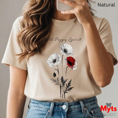 A woman wearing a Natural graphic T-shirt with a poppy design and the text 'Wild Poppy Spirit', paired with blue jeans. The image is a mirror selfie with a phone, and the words 'Natural' and 'Myts designs' are visible.