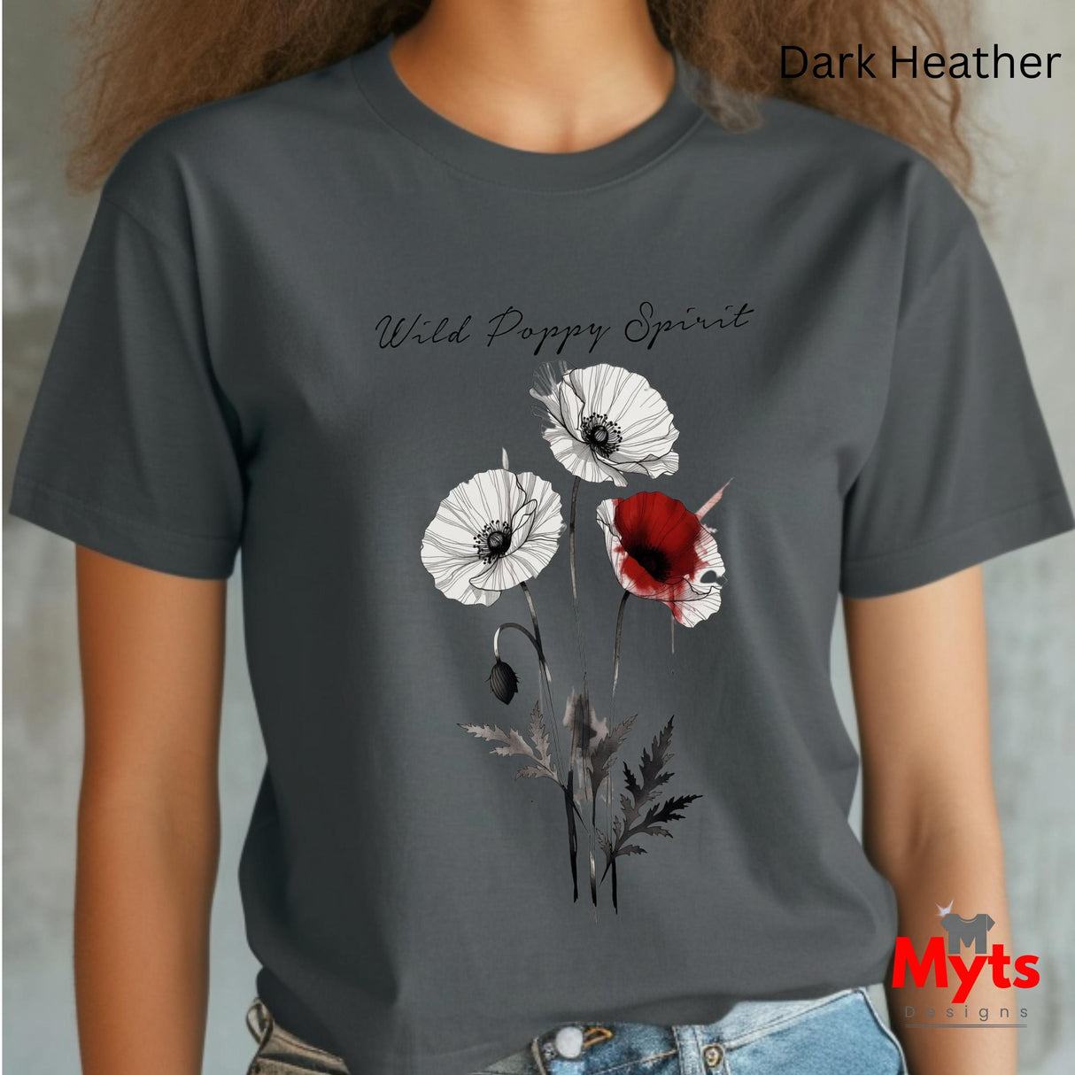 A woman wearing a dark heather gray t-shirt with a graphic of three wild poppies (two white, one red) and the text 'Wild Poppy Spirit'.