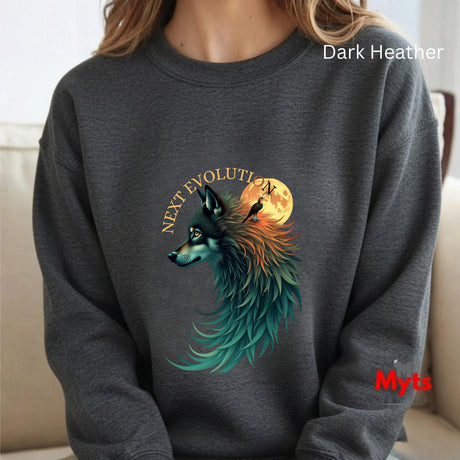 A person wearing a dark heather gray crewneck sweatshirt with a graphic of a wolf with teal, orange, and black feathers in front of a full moon, with the text 'NEXT EVOLUTION' above it. The sweatshirt has 'Dark Heather' text in white in the top right and a red 'Myts' logo in the bottom right.